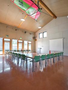 Großes Zimmer mit einem langen Tisch und Stühlen in der Unterkunft Youth Hostel Lultzhausen in Lultzhausen