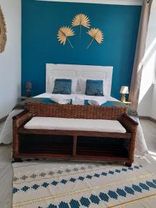 1 dormitorio con 1 cama grande y pared azul en Casa Chanel en Figueira da Foz