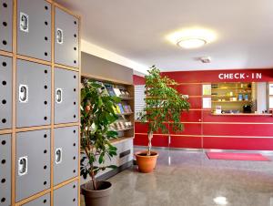 - une bibliothèque avec des plantes, des casiers et un comptoir d'enregistrement dans l'établissement Youth Hostel Lultzhausen, à Lultzhausen
