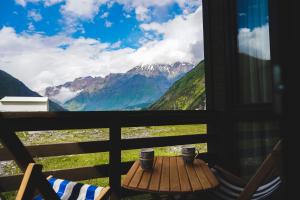 a view from a balcony with a table and mountains at Patara cottage, Stepantsminda, Achkhoti, in Kazbegi