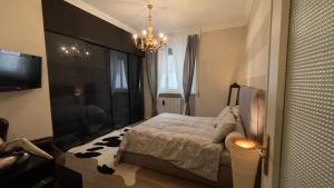 1 dormitorio con 1 cama, TV y lámpara de araña en Boadream - Lussuoso appartamento in centro storico, en Parma