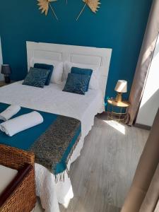 a bedroom with two beds with blue walls at Casa Chanel in Figueira da Foz