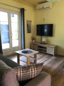 a living room with a couch and a tv and a table at Apartment Klesinger in Poreč
