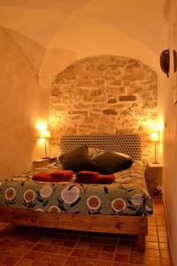 een slaapkamer met een bed met een stenen muur bij Gîte 'An Kay Ou' - L'Aiglette in Pontaix