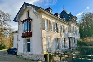 une maison avec une voiture garée devant elle dans l'établissement Château Viéndal proche Vittel et Contrexéville, 