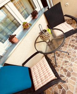 a glass table and chairs on a patio at Charme apartman in Kruševac