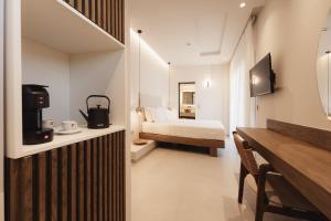 a hotel room with a bedroom with a bed at ĪKYMA Boutique in Polychrono