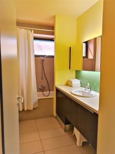 a bathroom with a sink and a shower at Soleil Apartmanok Balatonlelle in Balatonlelle