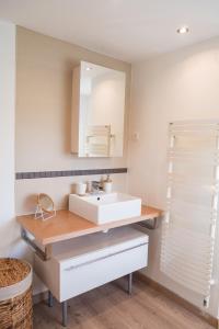 W łazience znajduje się biała umywalka i lustro. w obiekcie La Petite Maison w mieście Charly