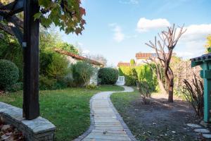 a path in a garden with a pole at La Petite Maison in Charly