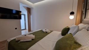 a bedroom with a large bed with towels on it at Magdalena Suite 4.0 in Heraklio Town