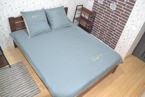 ein blaues Bett mit zwei Kissen und einer Ziegelwand in der Unterkunft Family & Relax Loft Lake House 