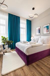 sypialnia z dużym łóżkiem z niebieskimi zasłonami w obiekcie Hotel Sofia by The Railway Station Wroclaw we Wrocławiu