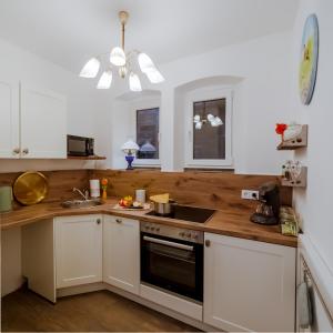 a kitchen with white cabinets and a wooden counter top at Alte Färberei - Wohnen in der Altstadt in Kulmbach