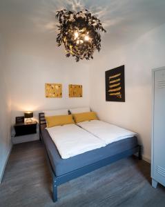 a bedroom with a bed and a chandelier at Alte Färberei - Wohnen in der Altstadt in Kulmbach
