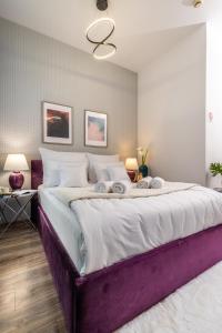 a large bed in a bedroom with a purple bed frame at Hotel Sofia by The Railway Station Wroclaw in Wrocław