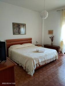 a bedroom with a bed and a flat screen tv at Room in Apartment - La Palma King Room With Balcony in Cagliari