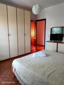 a bedroom with a large bed and a flat screen tv at Room in Apartment - La Palma King Room With Balcony in Cagliari