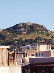 a building with a mountain in the background at Room in Apartment - La Palma King Room With Balcony in Cagliari