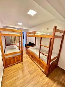 Lila Limao Hostel في أبراو: سريرين بطابقين في غرفة مع أرضيات خشبية