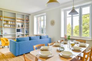 - un salon avec une table et un canapé bleu dans l'établissement La Maison de Famille - Superbe maison de maître, à Nantes