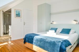 - une chambre dotée d'un grand lit avec des draps bleus et blancs dans l'établissement La Maison de Famille - Superbe maison de maître, à Nantes
