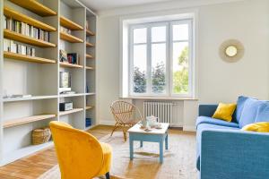 a living room with a blue couch and a table at La Maison de Famille - Superbe maison de maître in Nantes