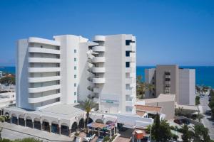 ein großes weißes Gebäude vor dem Meer in der Unterkunft Epsilon Hotel Apartments in Faliraki