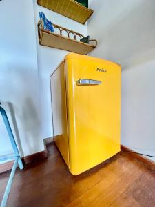 a yellow refrigerator in the corner of a room at O Petit Monde in Sanary-sur-Mer