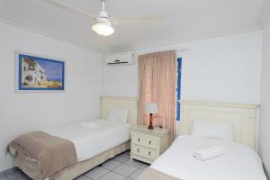 a bedroom with two beds and a lamp on a table at Le Paradis 5 - With Inverter in Ballito