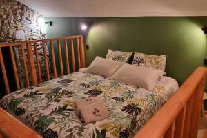 a bed in a bedroom with a green wall at Tropic Love Room in Lyon