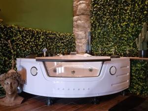 a bath tub with a statue in front of a wall at Tropic Love Room in Lyon