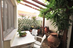 a patio with a table and chairs and plants at Orestis Mansion Skiathos in Skiathos