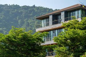 ein Gebäude mit Bäumen vor einem Berg in der Unterkunft Suite R4-5 The Height Khaoyai 2BR byน้องมังคุด in Ban Huai Sok Noi
