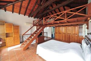 a bedroom with a large bed and a wooden ladder at Orestis Mansion Skiathos in Skiathos