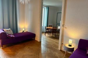 - un salon avec un canapé violet et une table dans l'établissement A 2 pas de Vittel et Contrexéville et proche Neufchâteau Château Viéndal, 