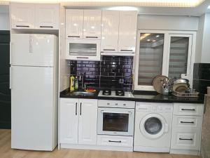 La cuisine est équipée de placards blancs et d'un réfrigérateur blanc. dans l'établissement Han Apart, à Istanbul