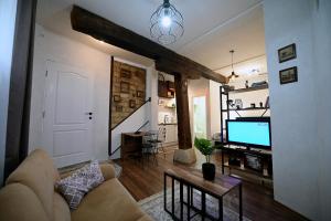 a living room with a couch and a flat screen tv at Apartments Magaza in Sarajevo