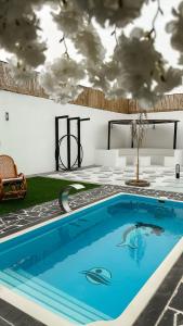 a swimming pool in a room with a ceiling with clouds at شاليه الجبل in Ḑubā