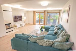 un soggiorno con divano blu e TV di Palmowe Wzgórze Skoszewo - Luksusowe Apartamenty a Skoszewo