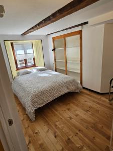 een slaapkamer met een bed en een houten vloer bij Airolo with private parking in Airolo