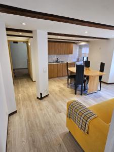a living room and kitchen with a table and a couch at Airolo with private parking in Airolo