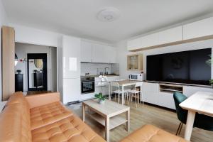 ein Wohnzimmer mit einem Sofa und einer Küche in der Unterkunft Pick A Flat's Apartment in Montparnasse - Rue Vercingétorix in Paris