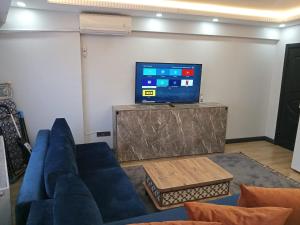 un salon avec un canapé bleu et une télévision dans l'établissement Han Apart, à Istanbul