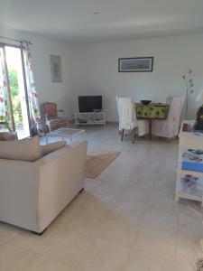a living room with a couch and a table at Villa Nancea Bassin Arcachon Gujan Mestras in Gujan-Mestras