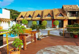 Casa con terraza de madera con macetas en Pousada Bangalôs Da Mole - Florianópolis en Florianópolis