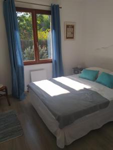 a bedroom with a bed with blue curtains and a window at Villa Nancea Bassin Arcachon Gujan Mestras in Gujan-Mestras