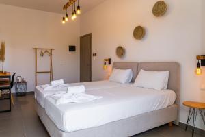 a bedroom with two beds with white sheets at Eleftheria Studios in Antiparos