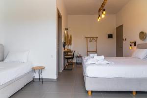 a bedroom with two beds and a table at Eleftheria Studios in Antiparos