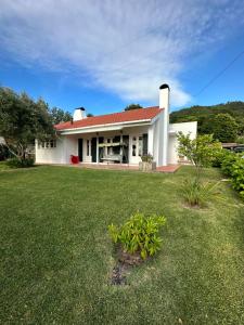 una casa blanca con un césped verde delante de ella en Cozy Villa Cristelo - Family & Friends, en Cristelo
